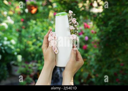 Beauty natürliche Hautpflegeprodukte Entwicklungskonzept. Dermatologe Hände halten leere kosmetische Hautpflegeflasche mit Bio-Inhaltsstoff auf Natur Bac Stockfoto