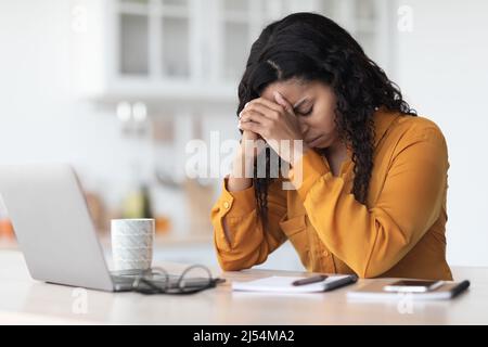 Müde afroamerikanische Dame erlebt Burnout, arbeitet online Stockfoto