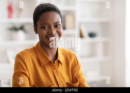Porträt einer glücklichen jungen schwarzen Frau, die im Büro posiert Stockfoto