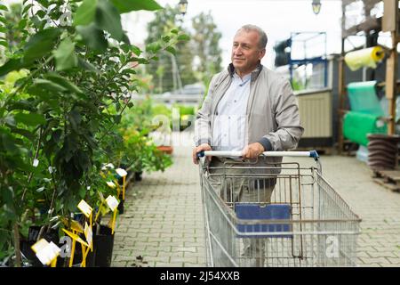 Kaukasischer Mann, der Sprossen im Gartencenter auswählt Stockfoto