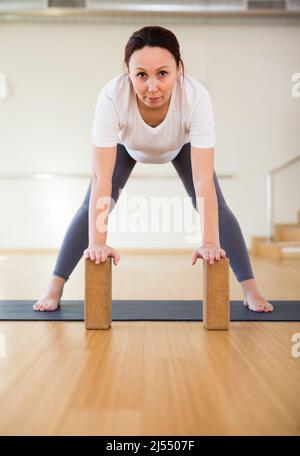 Eine Schwangerin ist im Yoga engagiert. Steht zur Hälfte nach vorne oder Ardha Uttanasana Stockfoto