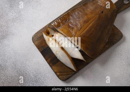 Frisch geräucherter Heilbutt auf braunem Hintergrund geschnitten. Blick von oben. Gesunde Omega-3 ungesättigte Fette gut für Gehirn und geistige Klarheit. Stockfoto