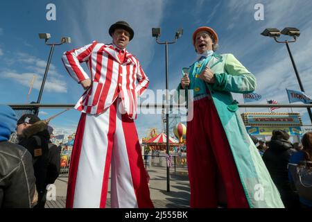 Männer auf Stelzen bei der Saisoneröffnung für Deno's Wonder Wheel Amusement Park auf der Promenade in Coney Island, Brooklyn, New York City, Stockfoto