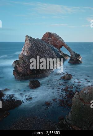 Atemberaubende Aussicht auf die Klippen im Mondschein an der nordschottischen Küste. Berühmte Felsformation an der Moray Coast, Bow Fiddle Rock. Schottische Highlands, Schottland Stockfoto