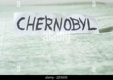 Tschernobyl, Wort auf einem Papier geschnitten und an einem hellgrünen Ort platziert. Stockfoto