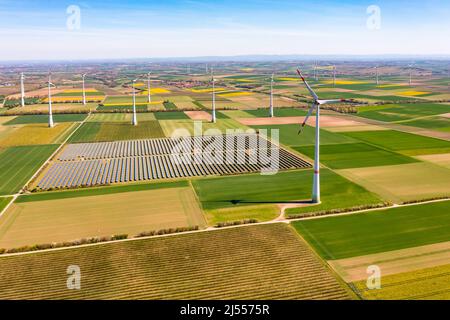 Luftaufnahme von Windturbinen und Sonnenkollektoren eines Solarparks zwischen Feldern in Rheinland-Pfalz, Deutschland Stockfoto