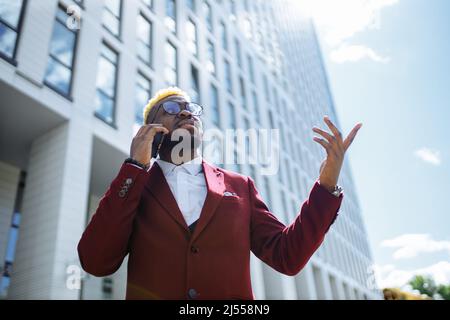 Happy Latino spanien Mode-Manager in der marsala Jacke in der Stadt im Freien sonnigen Sommer guten Tag Stockfoto