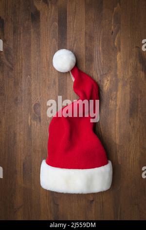 Weihnachtsmann Hut auf einem hölzernen Hintergrund. Weihnachten, Neujahr Stockfoto