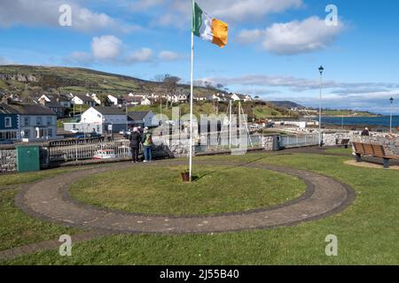 Irisches Tricolor, das über dem Hafen in der Küstenstadt Carnlough in North Antrim fliegt Stockfoto