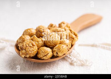 Goldenes Karamell-Popcorn in Holzpfanne, Crunchy und süßes Dessert Stockfoto