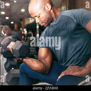 Foto von einem schwarzen Mann tun Push-ups mit einem Gewicht bar. Sport und Freizeit Stockfoto