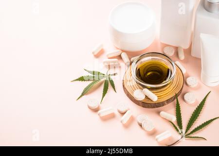 Cannabiskosmetik, Pillen und CBD-Öl bei rosa. Stockfoto