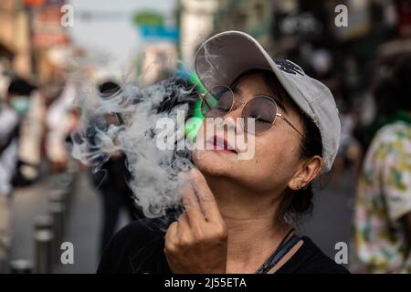 Bangkok, Thailand. 20. April 2022. Eine Frau atmet während eines 4/20. märz in Bangkok, Thailand, Rauch aus. (Bild: © Andre Malerba/ZUMA Press Wire) Stockfoto