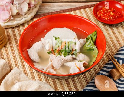 Geschnittene ​​meat Suppe in einer Schüssel mit Löffel und Essstäbchen isoliert auf Matte Seitenansicht auf Holztisch taiwan Essen Stockfoto