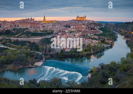 Ein Abend in Toledeo mit Blick auf die Kathedrale und den Alcázar von Toledo vom Mirador Panoramico aus gesehen. Der Alcázar von Toledo ist eine steinerne Festung Stockfoto