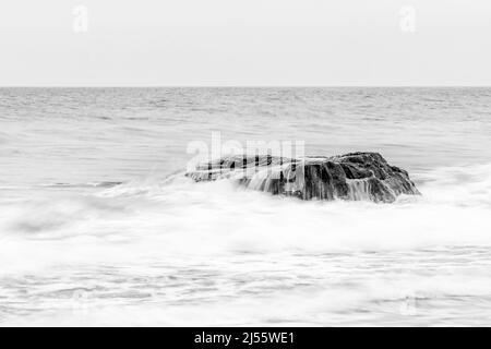 Wellen krachen über Felsen bei Whistling Sands, Porthor, Lleyn Peninsula, Wales Stockfoto