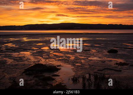 Arnside, Milnthorpe, Cumbria, Großbritannien. 20. April 2022. Sonnenuntergang in der Nähe von Arnside, Cumbria, Teil der Morecambe Bay, der größten Fläche von Gezeitenschlammflächen und Sand im Vereinigten Königreich Quelle: John Eveson/Alamy Live News Stockfoto