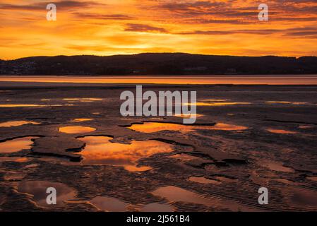 Arnside, Milnthorpe, Cumbria, Großbritannien. 20. April 2022. Sonnenuntergang in der Nähe von Arnside, Cumbria, Teil der Morecambe Bay, der größten Fläche von Gezeitenschlammflächen und Sand im Vereinigten Königreich Quelle: John Eveson/Alamy Live News Stockfoto