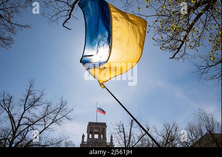 16.04.2022, Berlin, Deutschland, Europa - Vor der russischen Botschaft auf dem Boulevard unter den Linden in Mitte winkt Eine ukrainische Nationalflagge. Stockfoto