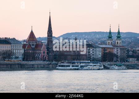 Schlanker Glockenturm und ungarische Dachziegel aus neugotischer Szilágyi Dezsö-Platz Reformierte Kirche und barocke Türme der St. Anne-Kirche in Budapest. Stockfoto