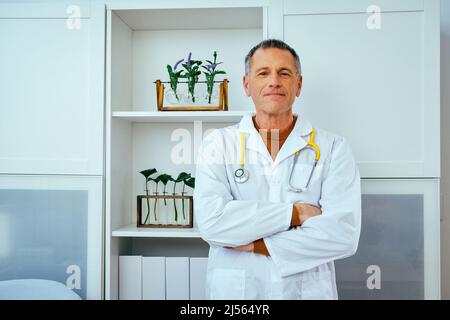 Porträt eines nachdenklichen männlichen Arztes mit Stethoskop, der die Kamera in der Krankenhausindustrie betrachtet Stockfoto