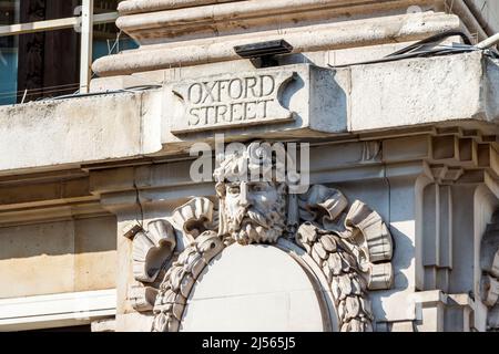 Straßenname und Skulptur aus geschnitztem Stein in der Oxford Street, London, Großbritannien Stockfoto