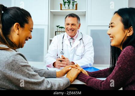 Lächelnde Ärztin und glückliche Erwachsene Patientinnen in der Arztpraxis im Gesundheitswesen Stockfoto