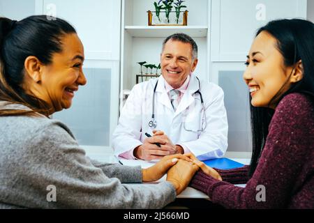 Lächelnde Ärztin und glückliche Erwachsene Patientinnen in der Arztpraxis im Gesundheitswesen Stockfoto