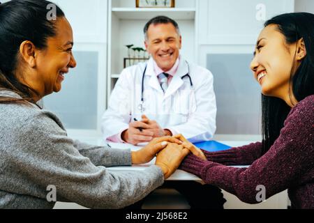 Lächelnde Ärztin und glückliche Erwachsene Patientinnen in der Arztpraxis im Gesundheitswesen Stockfoto