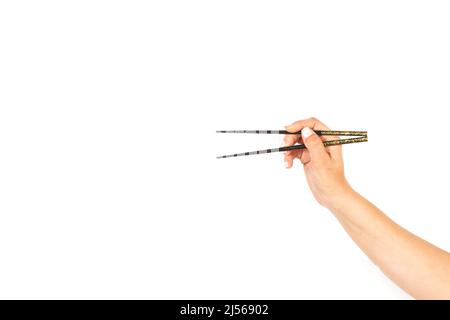 Frau Hand hält Essstäbchen auf einem weißen Hintergrund mit Kopierraum Stockfoto