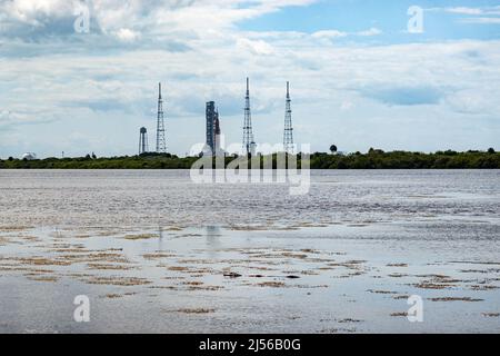 Cape Canaveral, FL USA - 20. April 2022: Ein seltener Blick auf die Artemis Rakete, die Astronauten mit einem Alligator im Vordergrund auf den Mond bringen wird Stockfoto
