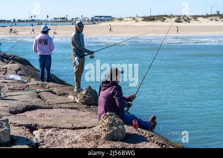 Salzwasserfischer auf der Anlegestelle des Schiffskanals des Brazos Santiago Pass auf South Padre Island, Texas. Stockfoto