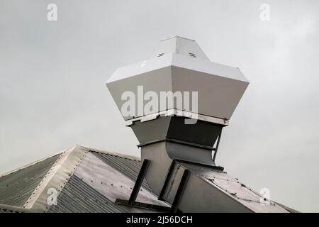 Küchenabluftventilator auf dem Dach eines Luxusresorthotels an einem bewölkten Tag. Stockfoto