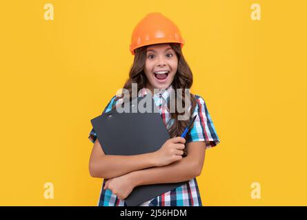 Wow. Überrascht Mädchen in schützenden Hut. Stauned Kind in Helm halten Projekt. Stockfoto