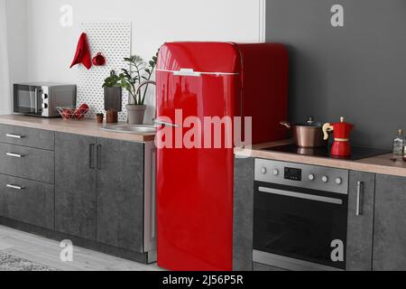 Roter Retro-Kühlschrank und moderne Arbeitsflächen in der Küche Stockfoto