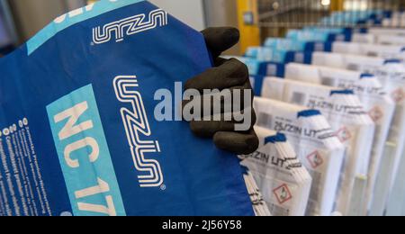 Ulm, Deutschland. 20. April 2022. Steffen Tietze platziert Papiertüten während der Produktion bei Uzin Utz in eine Abfülllinie. Der börsennotierte Baustoffhersteller stellt auf einer Jahrespressekonferenz am 21. April 2022 die Zahlen des Unternehmens für das vergangene Geschäftsjahr vor. Quelle: Stefan Puchner/dpa/Alamy Live News Stockfoto
