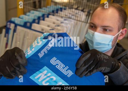 Ulm, Deutschland. 20. April 2022. Steffen Tietze platziert Papiersäcke während der Produktion bei Uzin Utz in eine Abfülllinie. Der börsennotierte Baustoffhersteller stellt auf einer Jahrespressekonferenz am 21. April 2022 die Zahlen des Unternehmens für das vergangene Geschäftsjahr vor. Quelle: Stefan Puchner/dpa/Alamy Live News Stockfoto