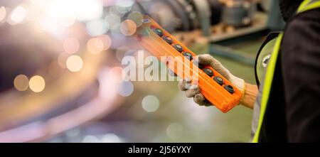 Arbeiter Mann Hand drücken Fernbedienungsschalter für Deckenkran in der Fabrik, Techniker, die Steuerung des Aufzugs in Fabrik Industrielager Stockfoto