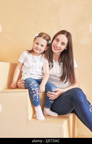 Frohe Familie. Mutter und Tochter zu Hause. Junge Frau und Mädchen. Mütter und Kinder Tag. Guten Morgen und Liebe Konzept. Helle Inneneinrichtung. Stockfoto