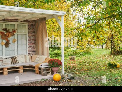 Herbst Ernte Terrasse Hintergrund. Halloween. Land. Kürbisse und Blumen. Ferienhaus. Erntedankfest Stockfoto