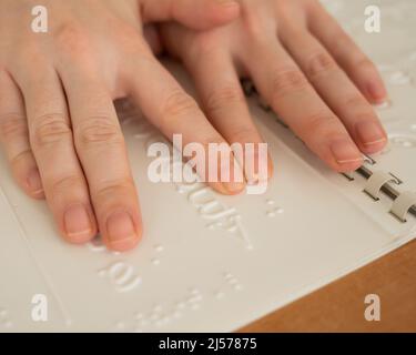 Eine Frau lernt das Braillealphabet mit einem Decoder. Stockfoto