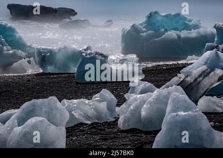 Eisbrocken am schwarzen Strand an der Gletscherlagune in Island (Jökulsárlón Diamond Beach). Stockfoto