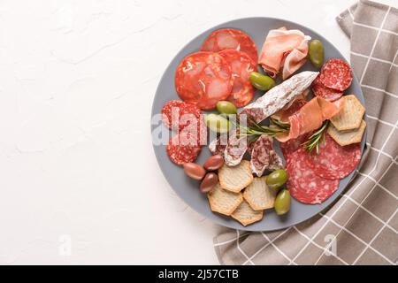 Auswahl an verschiedenen Fleischsnacks, Wurstplatte mit verschiedenen Wurstsorten - Salami, bresaola, Proscuitto serviert mit Oliven, Rosmarin und Stockfoto