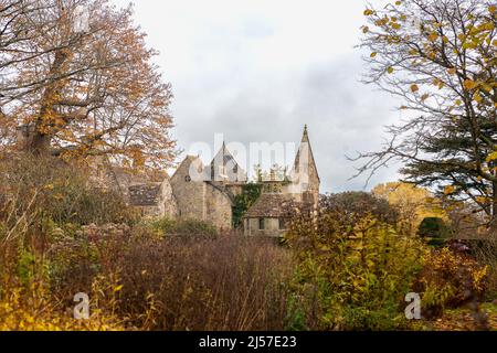 Spätherbst bei Nymans, mit dem teilweise ruinierten Haus, das von Bäumen eingerahmt ist: Nymans, West Sussex, Großbritannien Stockfoto