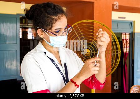 Impfung in Indien, Ärztin verabreichen einem Mädchen an der Carmel High School for Girls in Baruipur, Indien, eine Sinopharm-Impfinjektion zum Schutz vor Coronavirus oder Covid-19 Stockfoto