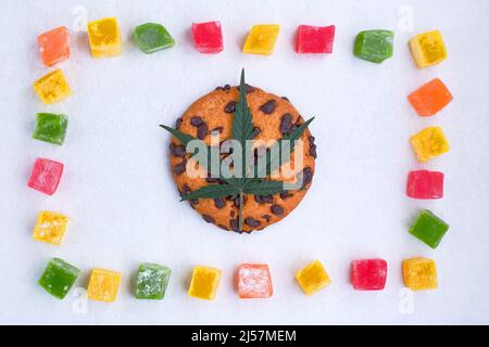 Süßigkeiten mit CBD-Öl. Amerikanische Küche mit Cannabisextrakt. Marihuana Blätter auf weißem Hintergrund. Draufsicht, flach liegend. Stockfoto
