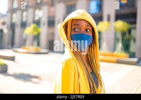 afroamerikanische Frau mit langen gelben Dreadlocks Zöpfen, die traurig und einsam auf der Straße der sity aussehen Stockfoto