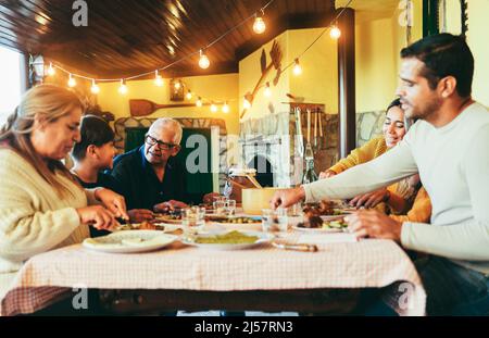 Glückliche lateinische Familie Spaß beim gemeinsamen Essen zu Hause - Fokus auf Großvater Gesicht Stockfoto