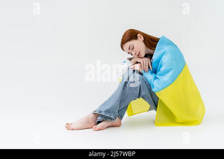 Junge Frau mit ukrainischer Flagge auf weißem Hintergrund Stockfoto