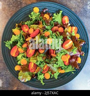 Teller mit frischem Salat aus Salat, Tomaten und Karotten. Stockfoto